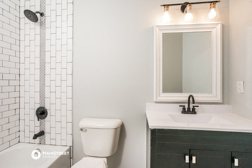 a bathroom with a toilet sink and shower and a mirror