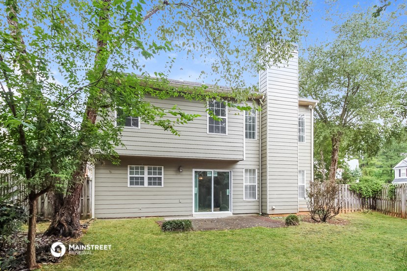 a white house with a yard and trees