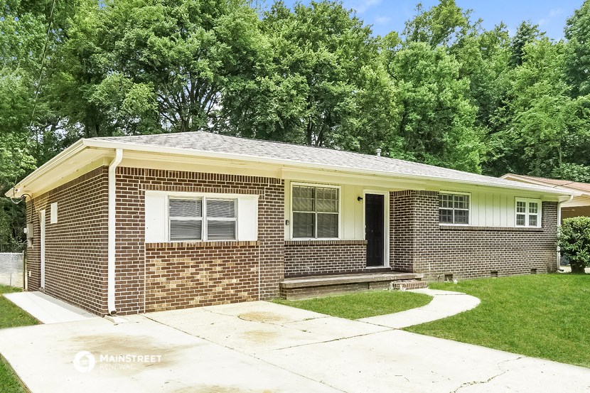 a brick house with a sidewalk in front of it