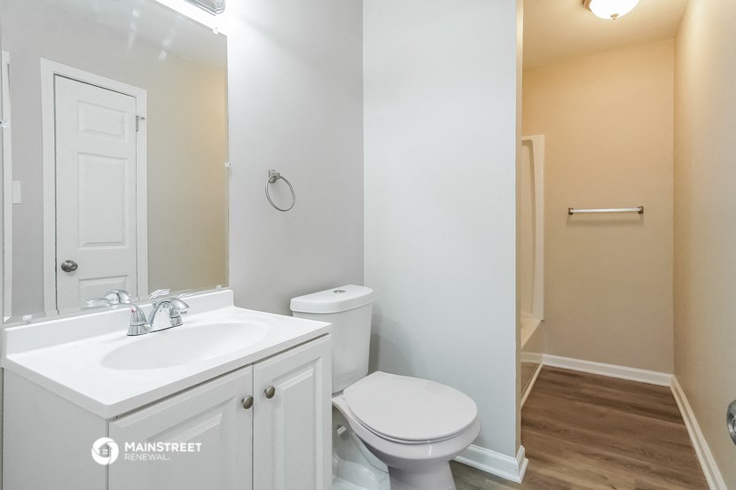 a bathroom with a toilet and a sink and a mirror