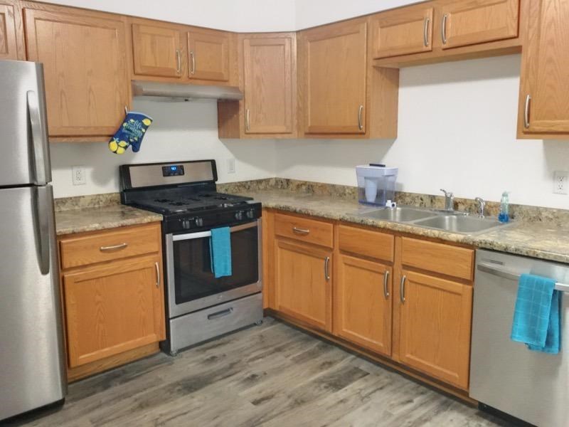 A kitchen with wooden cabinets and a black stove top oven.