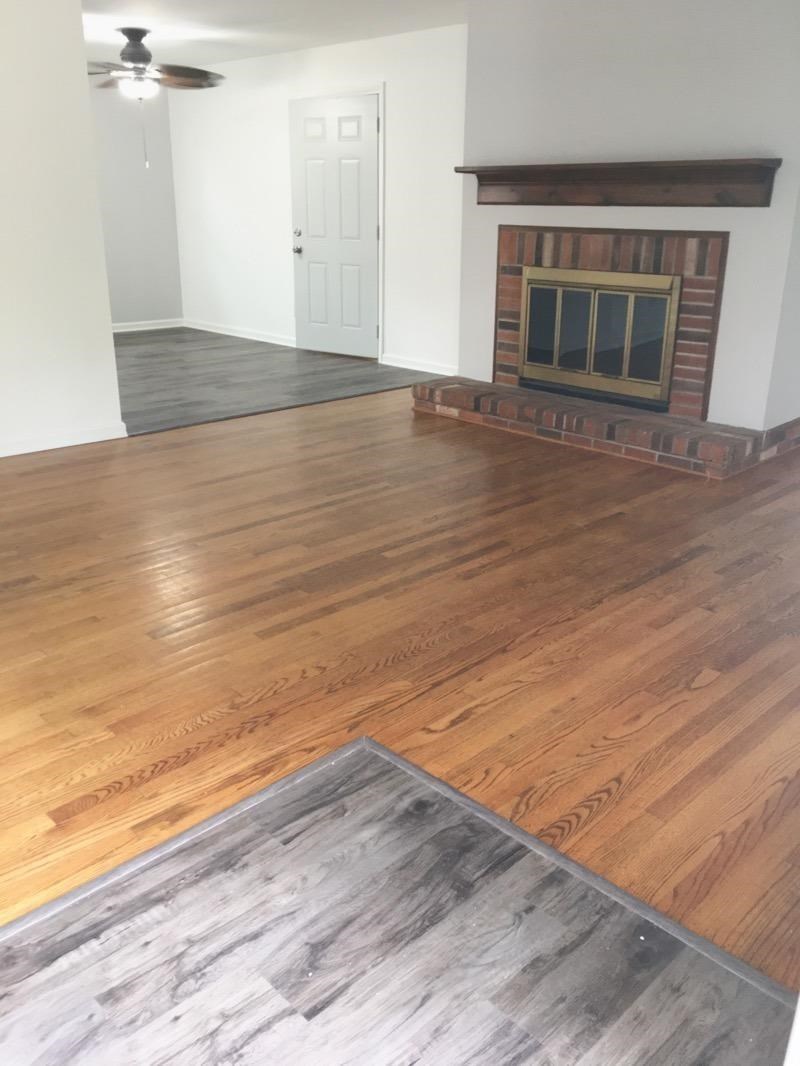 A room with a fireplace and a rug on the floor.