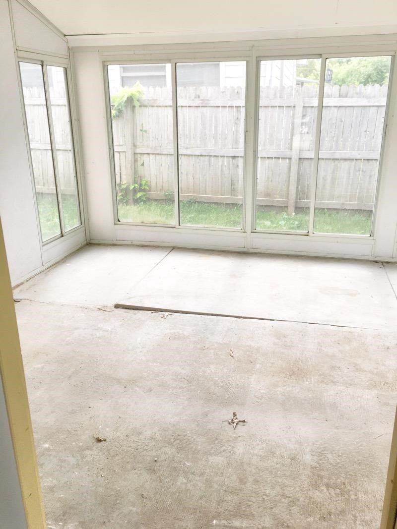 A room with a concrete floor and a large window.
