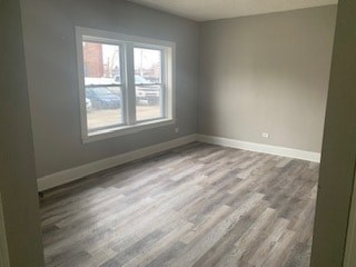 A room with a large window and wood flooring.