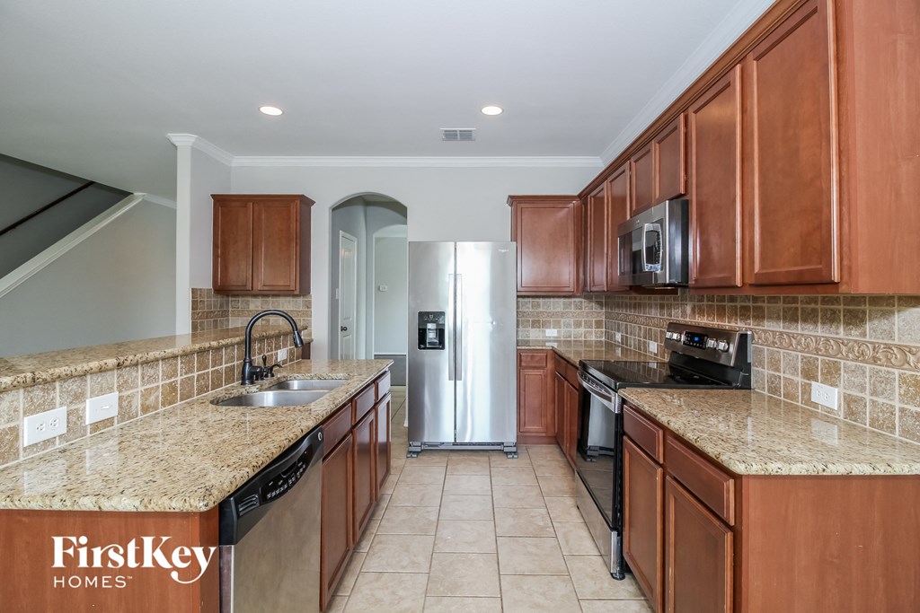 a kitchen with wooden cabinets and granite counter tops and a refrigerator
