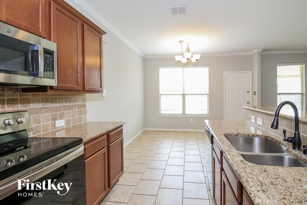 a kitchen with granite counter tops and wooden cabinets