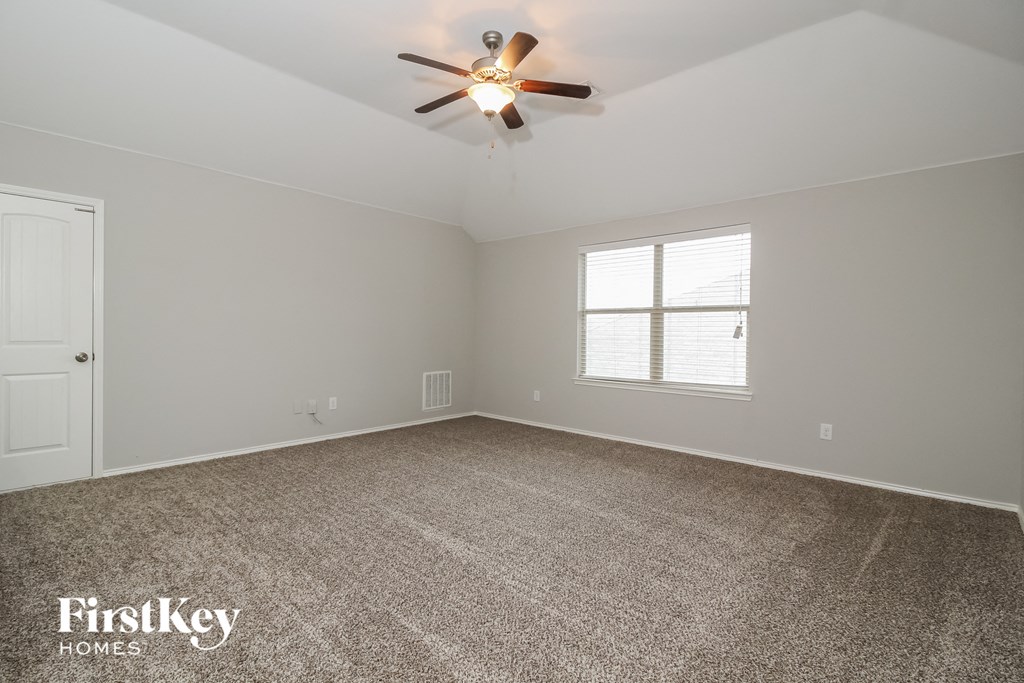 the living room of an empty house with a ceiling fan