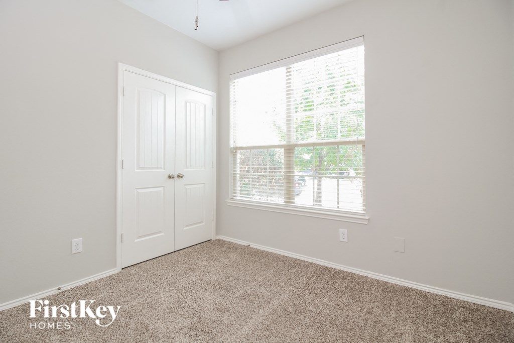 a bedroom with carpet and a window and a door