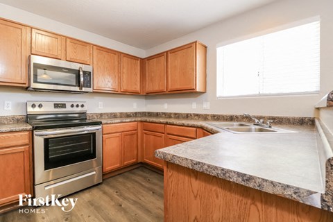 A kitchen with wooden cabinets and a granite countertop.