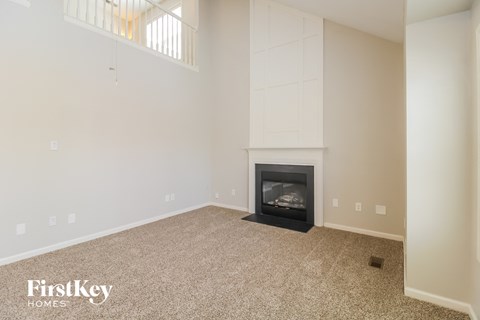 a living room with a fireplace and a white wall