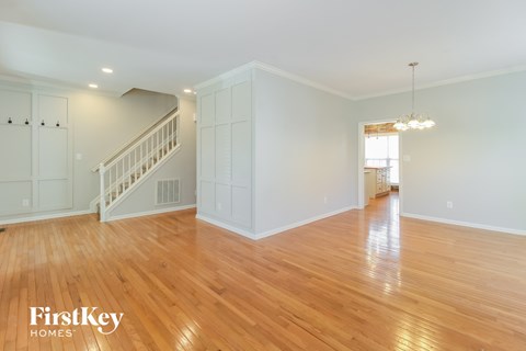 a living room with a staircase and a hardwood floor