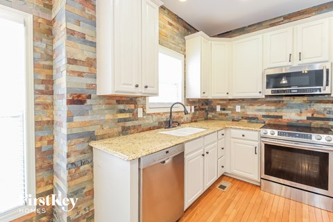 a kitchen with white cabinets and a counter top