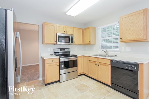 a kitchen with wooden cabinets and black appliances and a sink