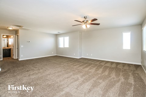 a living room with carpet and a ceiling fan