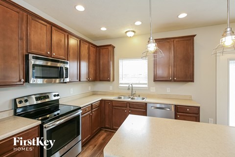A kitchen with wooden cabinets and a stainless steel oven.