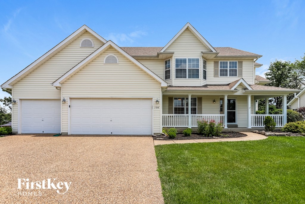 A two-story house with a garage and a driveway.