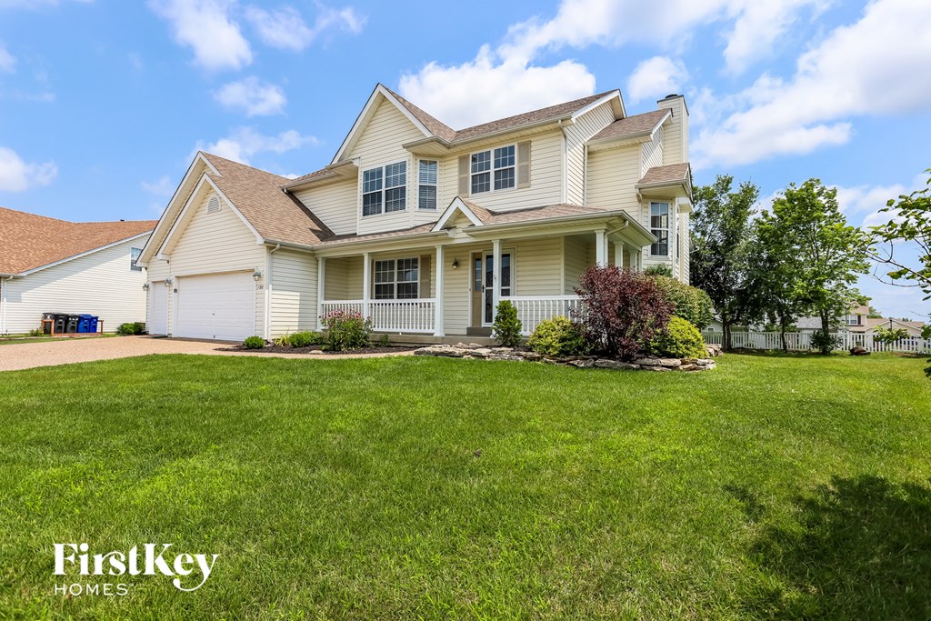 A large, well-maintained house with a lawn in front.