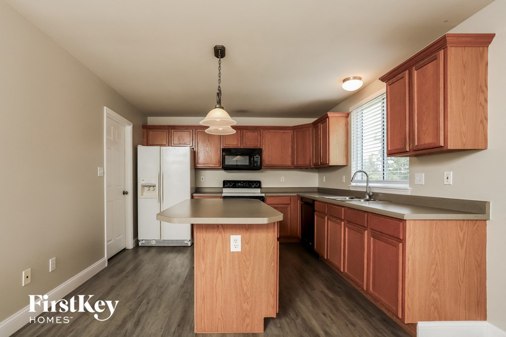 A kitchen with wooden cabinets and a white fridge.