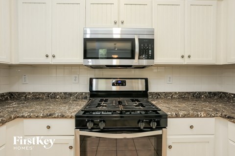 A kitchen with a stove and a microwave above it.