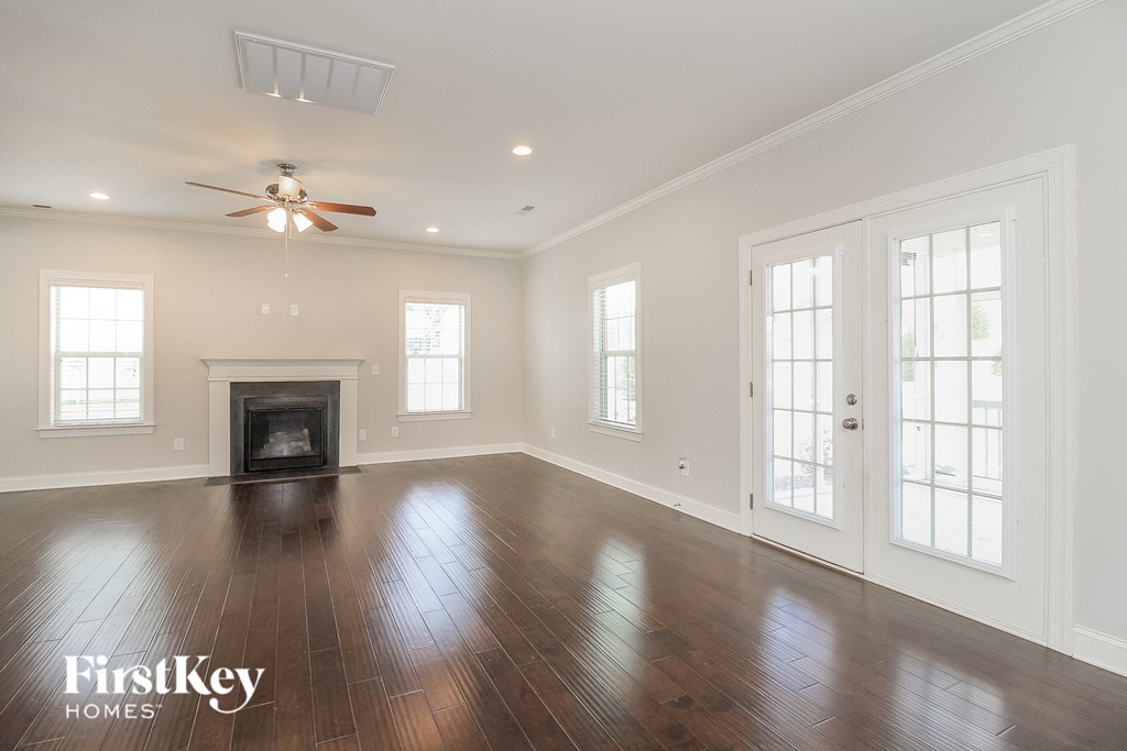 an empty living room with wood floors and a fireplace