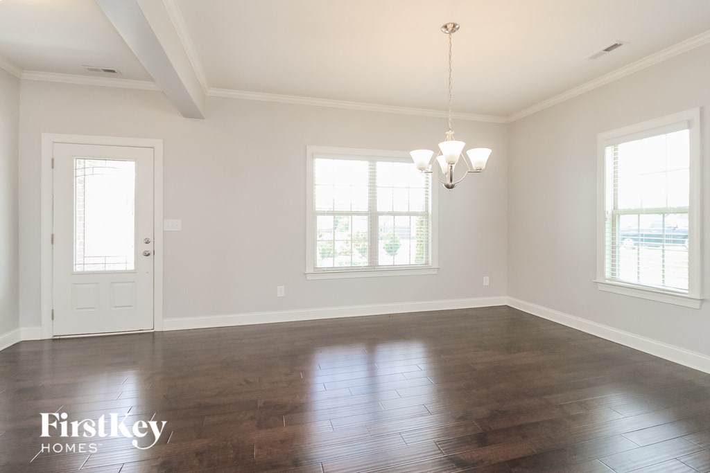 an empty living room with wood floors and white walls