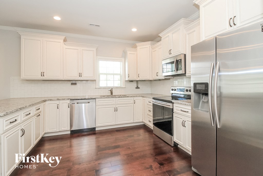 a white kitchen with stainless steel appliances and white cabinets