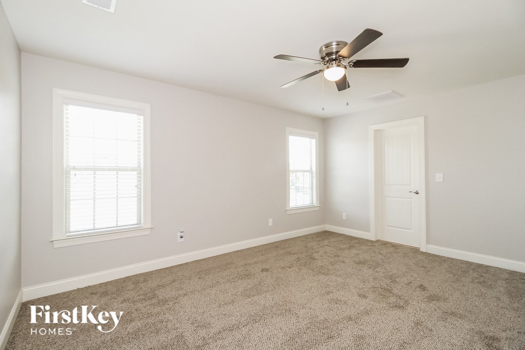 a bedroom with carpet and a ceiling fan