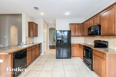 A kitchen with wooden cabinets and black appliances.