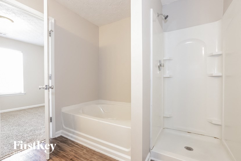 A white bathroom with a tub and shower.
