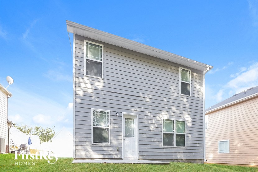 A grey house with a white door and windows.