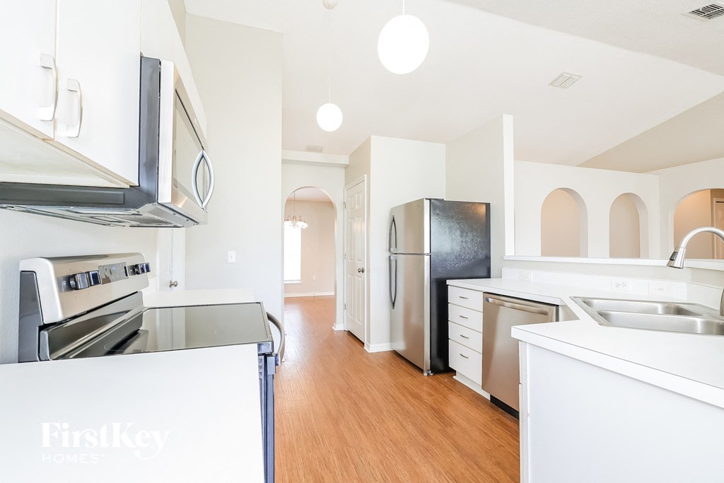 a renovated kitchen with white cabinets and stainless steel appliances