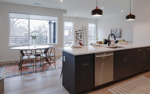A kitchen with a dining table and chairs.