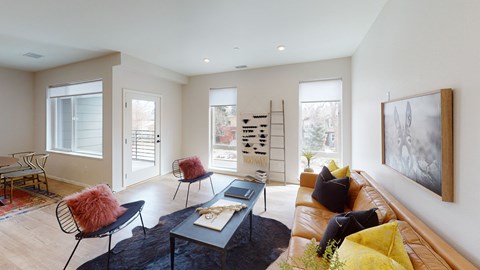 A living room with a brown couch, a black coffee table, and a painting on the wall.