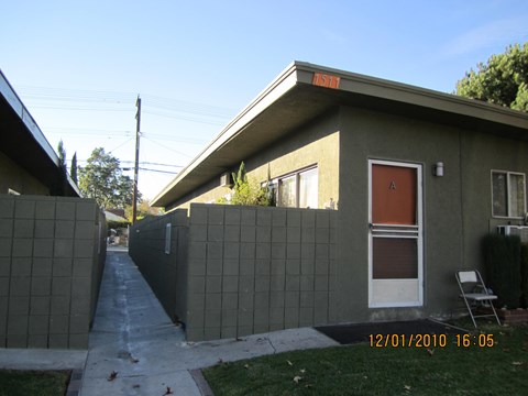 the front of a house with a fence and a sidewalk