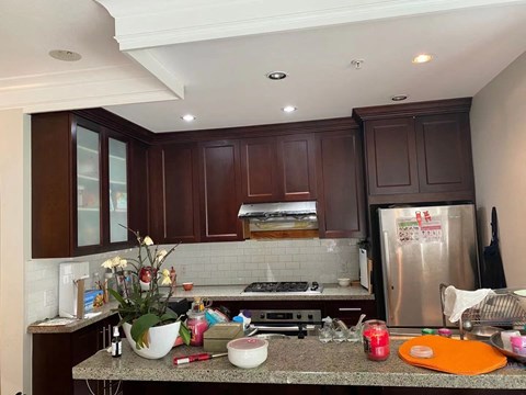 A kitchen with brown cabinets and a granite countertop.