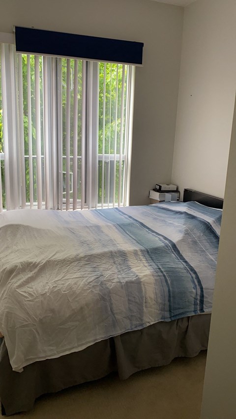 A bed with a white and blue striped comforter.