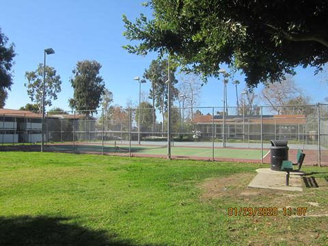 a park with a tennis court and a bench