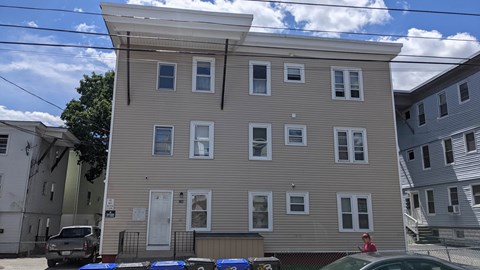 A two-story building with a grey facade and white trim.