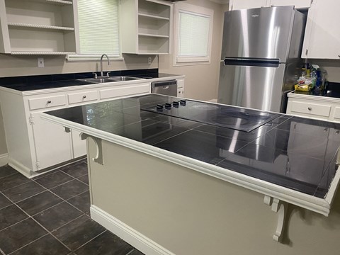 A kitchen with a stove top oven and a refrigerator.