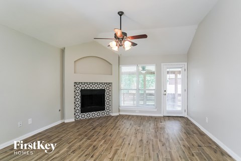 a living room with a fireplace and a ceiling fan