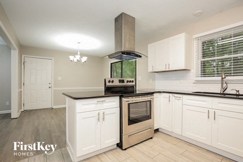 A kitchen with a stove top oven and a range hood.