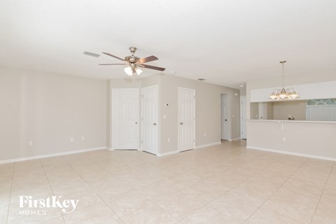 A spacious room with a ceiling fan and a chandelier.
