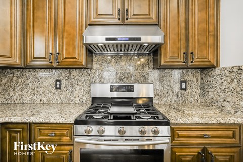 a kitchen with wood cabinets and a stainless steel stove