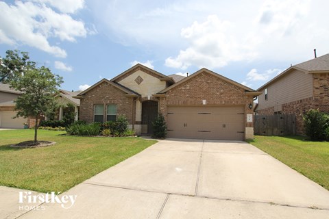 front view of a brick house with a driveway and a garage door