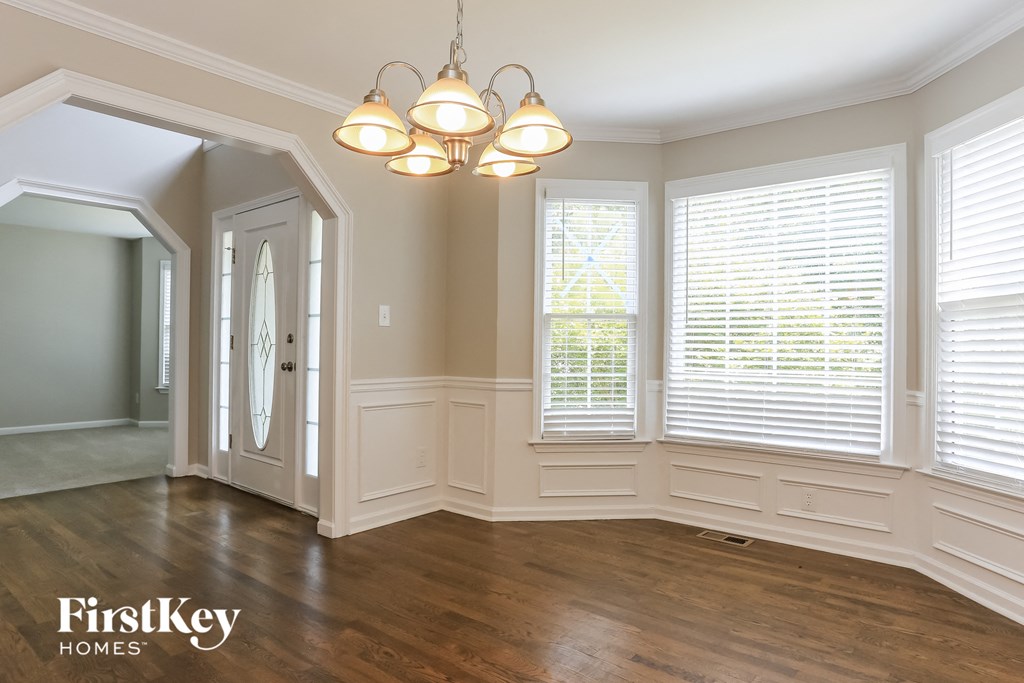 A well-lit room with wooden floors and a chandelier.