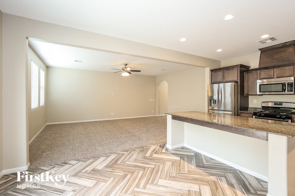A kitchen with a wooden floor and a stove top oven.