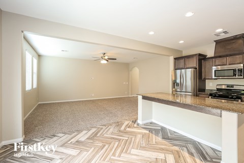A kitchen with a wooden floor and a stove top oven.