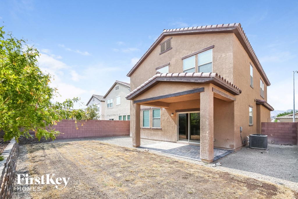 A house with a brown stucco exterior and a large patio area.