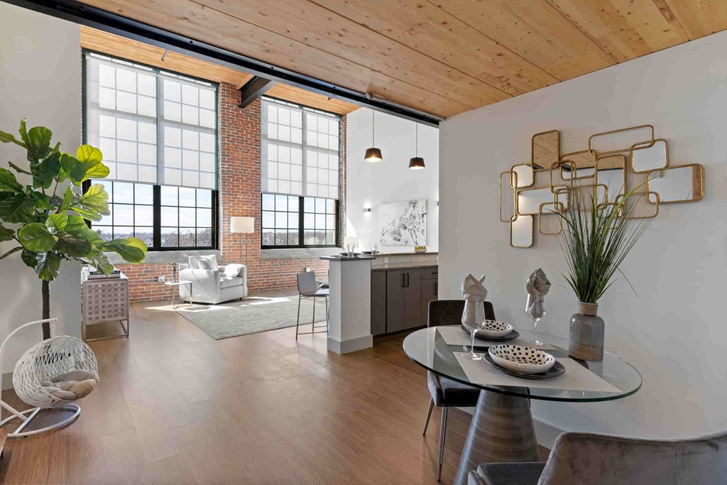 a living room with a table and a kitchen in a loft