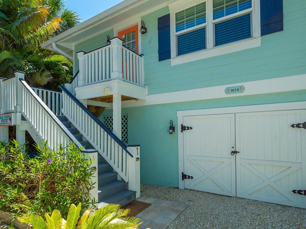 a blue house with white doors and a staircase